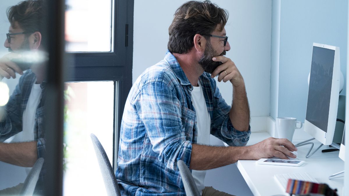 New sales manager thinking while reviewing his screen in a home office