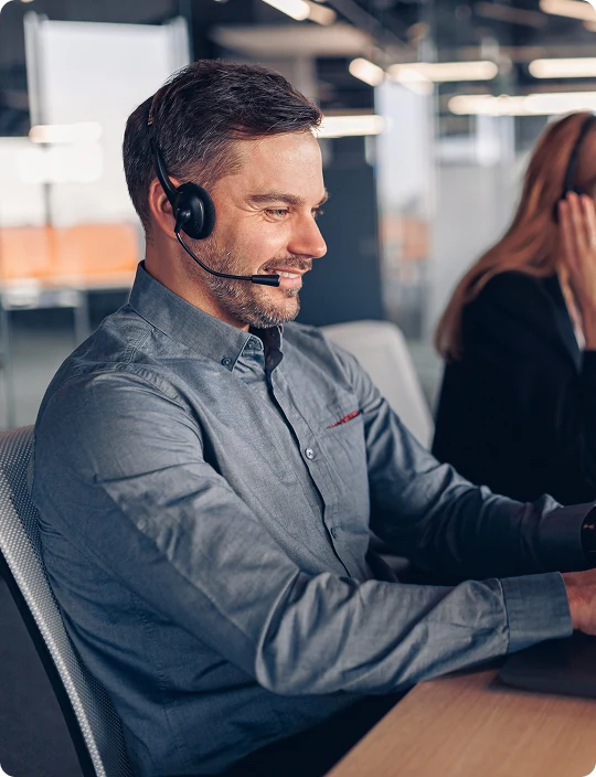 Dealership sales rep working at a computer with a headset