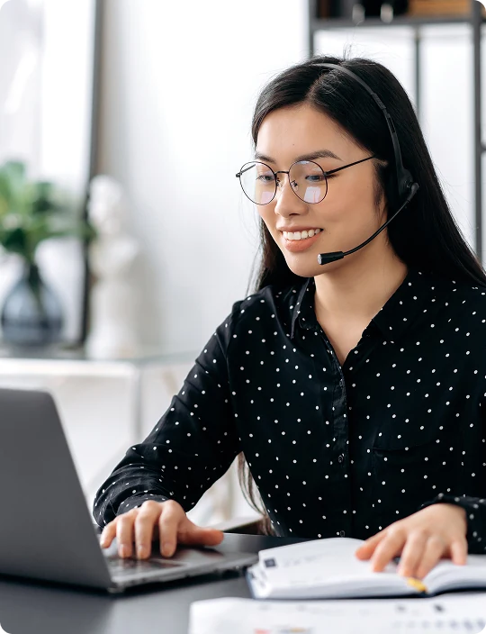 Sales rep on a call at a laptop with a headset